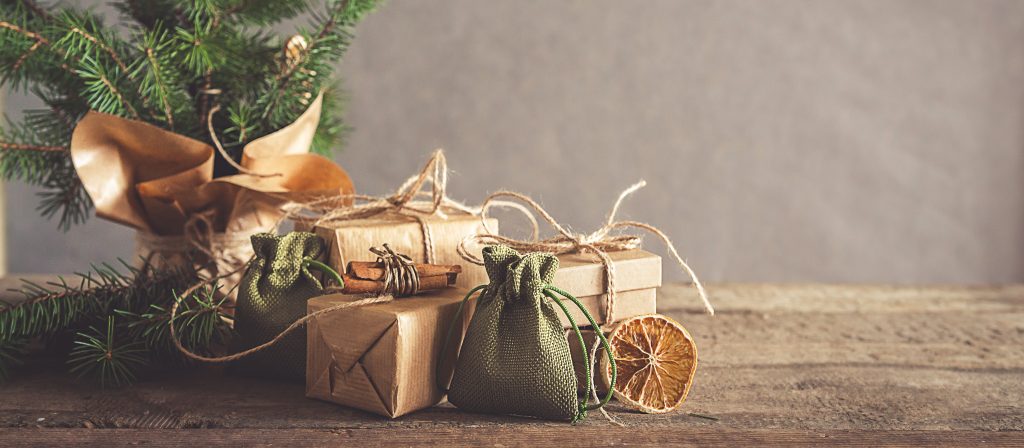 圣诞节和零浪费,生态友好的包装。女人在木质茶几上的牛皮纸包装礼物,圣诞节生态概念,生态装饰
